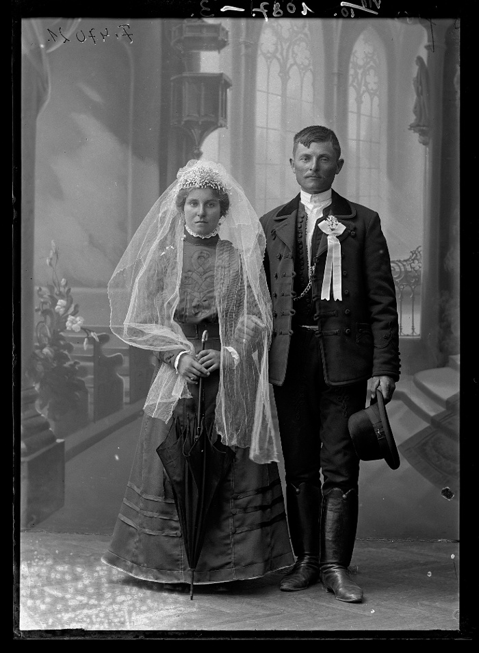 Menyasszony és vőlegény egy templombelsőt ábrázoló festett háttér előtt, Kecskemét, üvegnegatív, 13x18 cm, Fanto Bernát, 1910-es évek második fele, Néprajzi Múzeum, F 47021